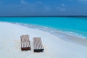 Close-up of sunbeds set on a beautiful tropical beach. Impressive image for every use.