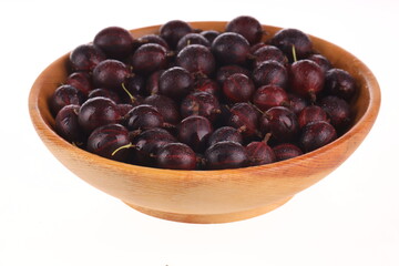heap pf red gooseberries in wooden plate  isolated on white. top view