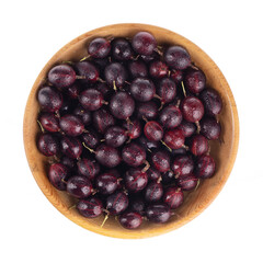 heap pf red gooseberries in wooden plate  isolated on white. top view