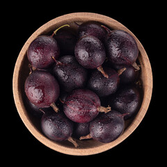 heap of black gooseberries with water drops in wooden cup isolated on black background