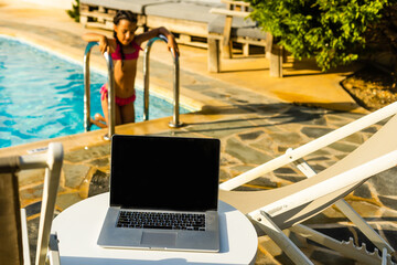 Obraz premium laptop computer on table pool background