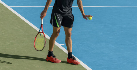 Young tennis player playing tennis on blue hard court. Male athlete with ball and racket is ready to serve at start of game. Sports background, copy space - obrazy, fototapety, plakaty