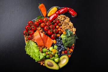 Healthy diet and nutrition for heart and cardiovascular system, healthy food, fruit and vegetables arrangement in realistic heart shape on black chalk board top view flat lay composition  © somegirl
