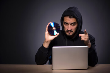Young male hacker on grey background