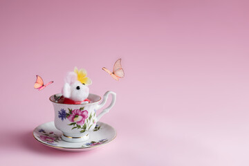 Topolino di lana nella tazza gioca con la farfalla