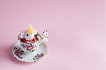 Topolino di lana nella tazza gioca con la farfalla