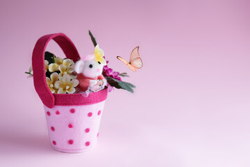 Topolino di lana nella tazza gioca con la farfalla