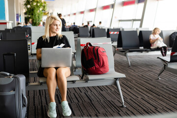 Business woman with suitcase in hall of airport