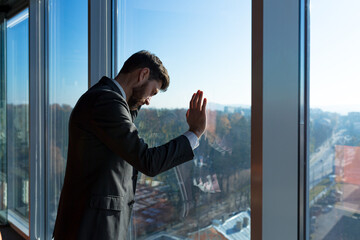 Bankrupt businessman boss, frustrated looking out the window, man in business suit, depressed and frustrated, in modern office