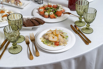 A bowl of Caesar chicken salad, on a wooden background. Festive salad.