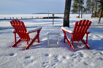 Empty red lawn chairs in winter snow - Powered by Adobe