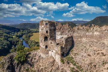 Fototapeta na wymiar Aerial view of the entrance to Sasovsky castle above the Hron river in Slovakia with double defensive structure protecting the gate cloudy blue sky