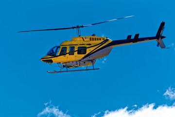 Side view of yellow crop spraying helicopter