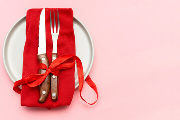 Valentine's Day, Womens day table serving with cutlery and red napkin on pink background. Romantic dinner, love, date concept. Top view flatlay copy space
