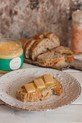 Ghee butter in glass jar and sliced bread on table. Healthy eating, breakfast