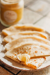 Ghee butter in glass jar and pancakes on table. Healthy eating, breakfast