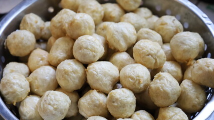 Close up fried meatballs. A pile of fried meatballs in a basin with holes to drain the oil. Selective focus