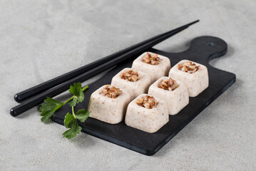 Buckwheat cream jelly in the form of small portions of a square shape on a serving board on a light gray background