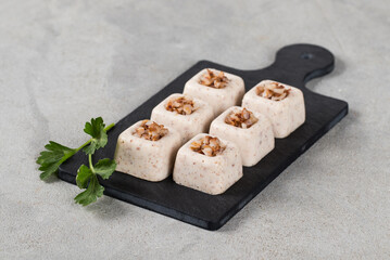 Light appetizer, Buckwheat cream jelly in the form of small portions of a square shape on a serving board on a light gray background