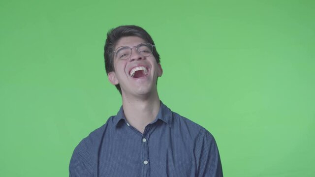 hombre latino riendose muy fuerte con fondo verde