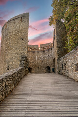 Obraz premium View of the walls and road leading to the famous barbakan (barbican) a round shape defensive structure protecting the town entrance with loop holes and sunset colorful sky in Pecs Hungary