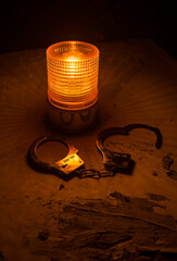 Police raid at night and you are under arrest concept. Silhouette of handcuffs with police car on...