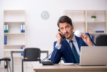 Young male employee drinking coffee during break