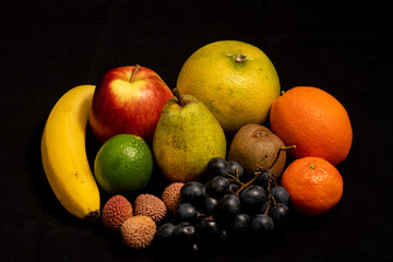 still life, fruits on a black background, various fruits