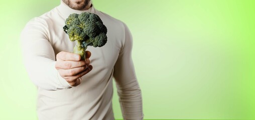 holding broccoli as symbol of healthy lifestyle