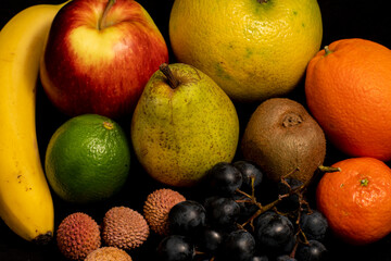 still life, fruits on a black background, various fruits