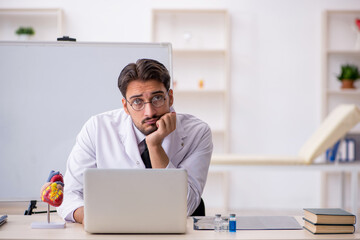 Young male doctor cardiologist sitting in the classroom