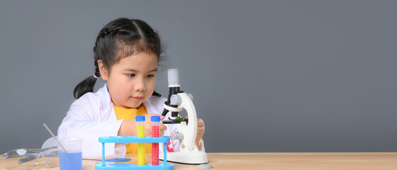 Asian child girl learning science chemistry with test tube making experiment at school laboratory....