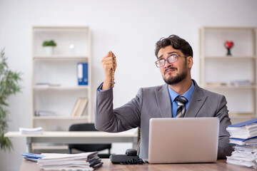 Young male employee unhappy with excessive work in the office