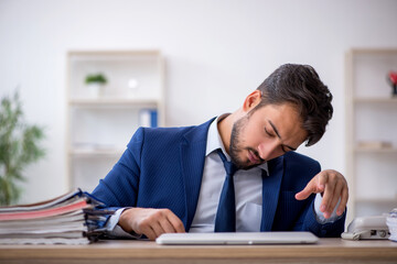 Naklejka premium Young male employee extremely tired in the office