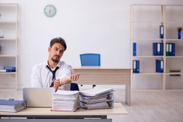 Young male employee and too much work in the office