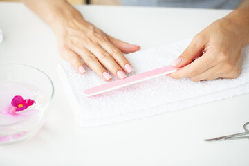 Obraz na płótnie Canvas Closeup of beautiful woman hands getting manicure at home