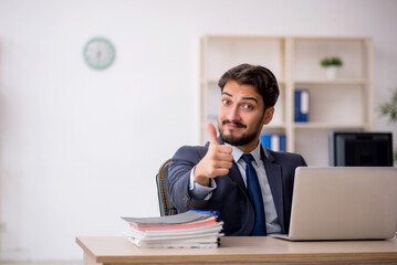 Naklejka premium Young male employee working in the office