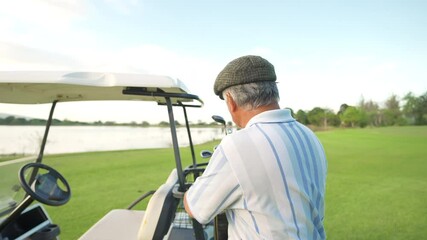 Portrait of Smiling Asian senior man golfer holding golf club standing on golf course in summer sunny day. Healthy elderly male enjoy outdoor lifestyle activity sport golfing at golf country club. - Powered by Adobe