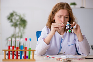 Young female chemist student studying molecular model