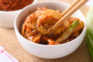 Kimchi cabbage in a bowl eating by use chopsticks, Korean homemade fermented side dish food
