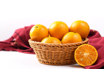 Fresh tangerine orange fruit in basket with red fabric on white background, Tropical fruit