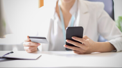 Businesswoman makes a purchase on the internet. Woman with smartphone and credit card.