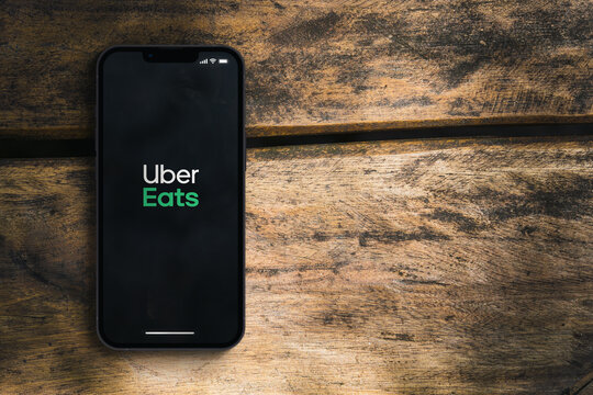 Uber Eats app on the smartphone screen on the rustic wooden table in the park. Top view. Rio de Janeiro, RJ, Brazil. January 2022