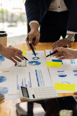 businessman holding pen working with financial graph and laptop with the calculator to analyze...