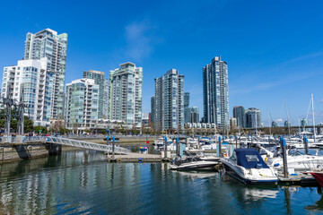 Vancouver city, BC, Canada - April 5 2021 : Yaletown dock marina, downtown apartment skyline reflection on the water.