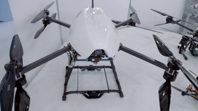 Modern huge powerful white quadrocopter with four twin propellers and a gasoline engine to generate electricity that turns the blades and with high definition video camera. Shot in motion