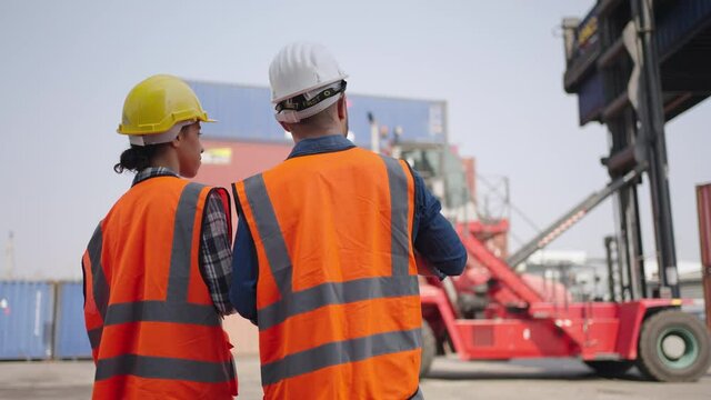 Logistic Export Import,transportation concept.smart creative foreman and engineer woman control loading container box from cargo freight ship,Engineer working on logistic industrial at cargo warehouse