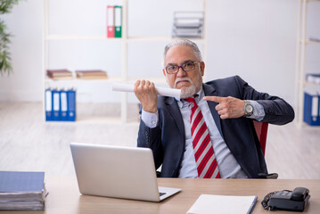 Old male employee working in the office