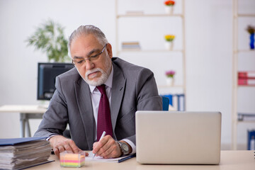 Obraz premium Old male employee sitting in the office