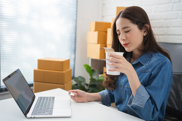 Asian businesswoman eating instant noodles for snack time. She is happy.